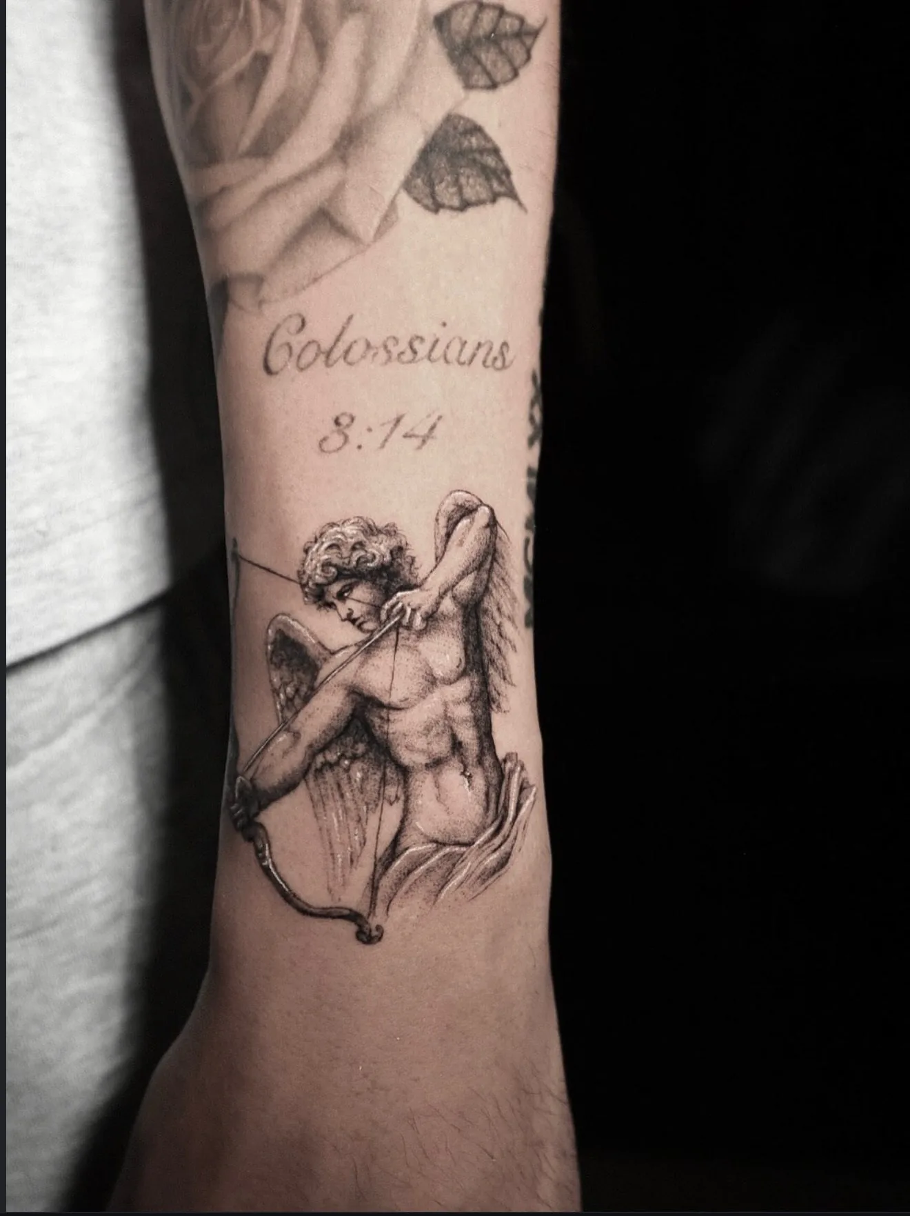 fine line tattoo, cupid and verse on the forearm