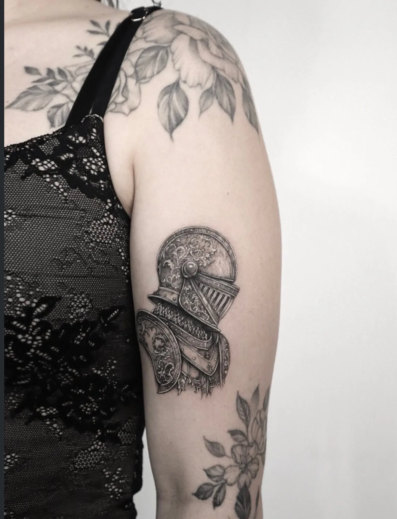fine line tattoo, statue and florals on the arm